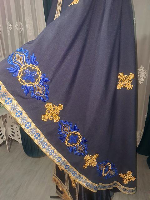 Detaliu de broderie albastră și aurie pe poala unui felon bleumarin